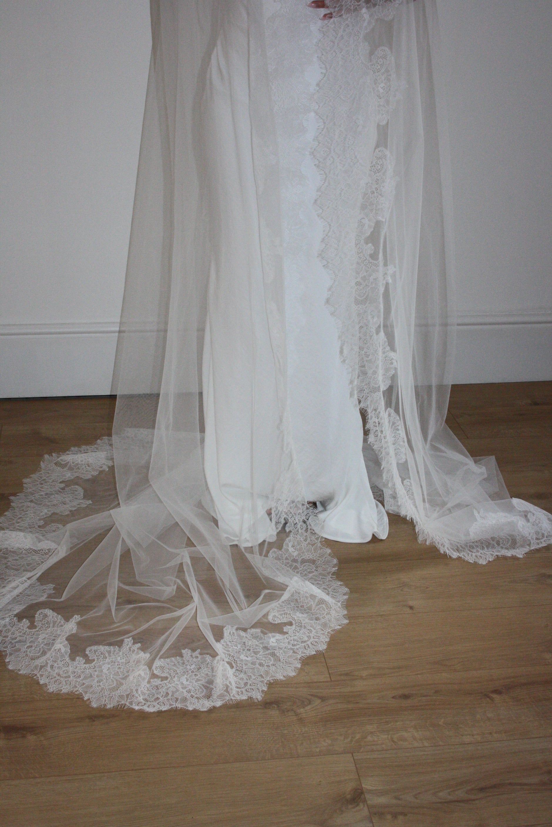 Cathedral-length wedding veil crafted from soft off-white tulle with an intricate Chantilly lace trim, ideal for brides wanting a romantic, elegant bridal accessory