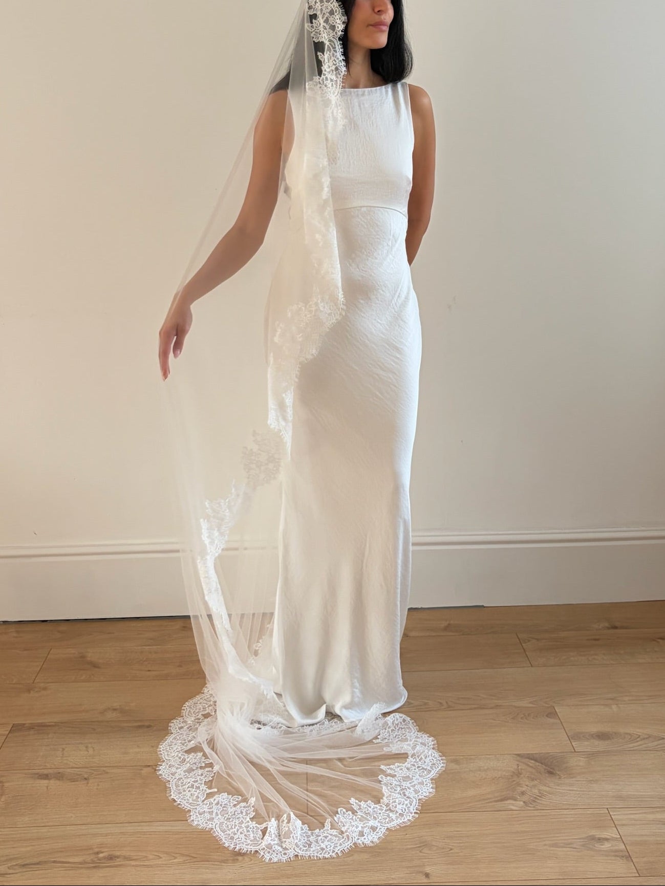 Soft off-white chapel bridal veil made from lightweight tulle with delicate lace trim along the edges for a dreamy, romantic look