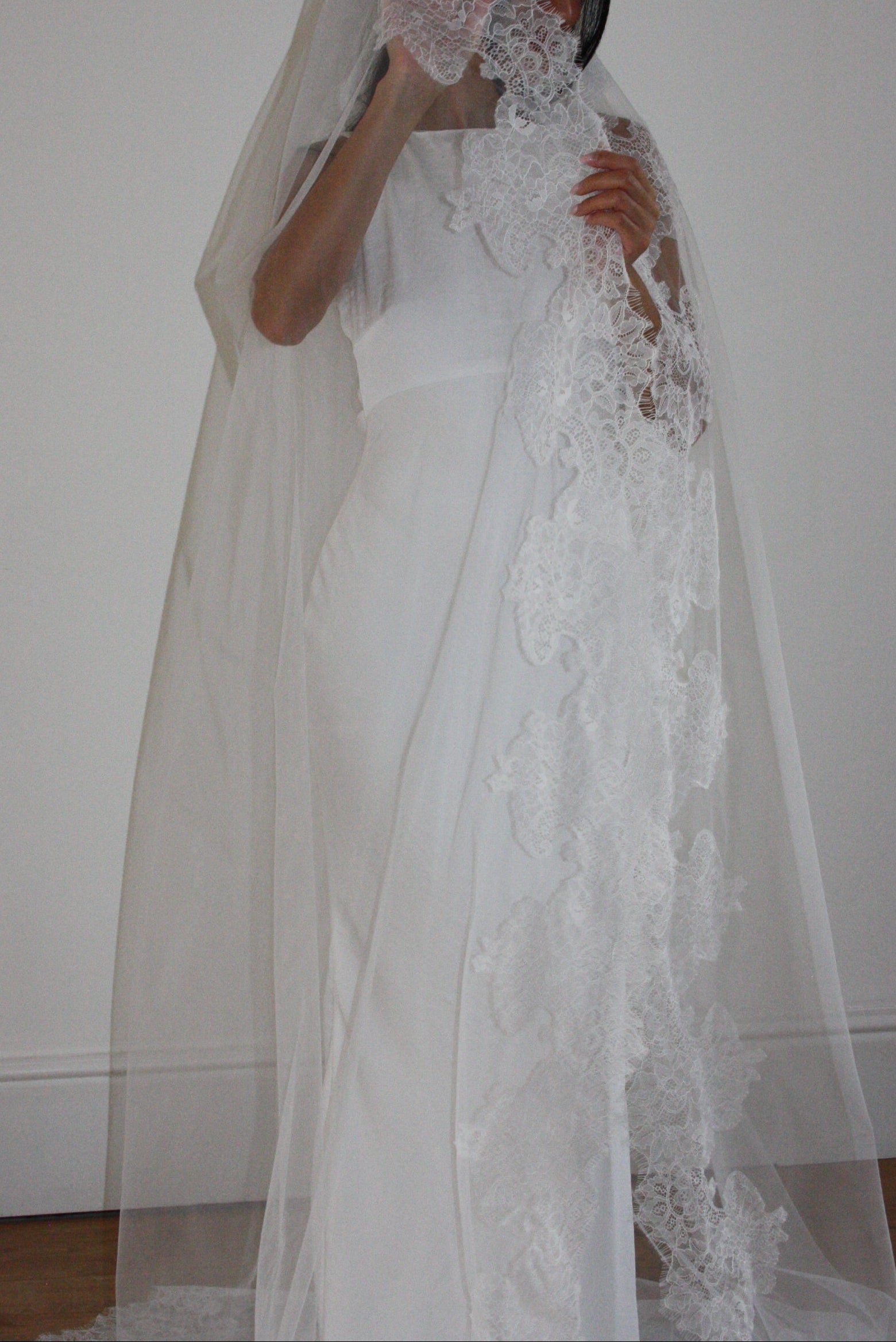 Cathedral-length wedding veil crafted from soft off-white tulle with an intricate Chantilly lace trim, ideal for brides wanting a romantic, elegant bridal accessory