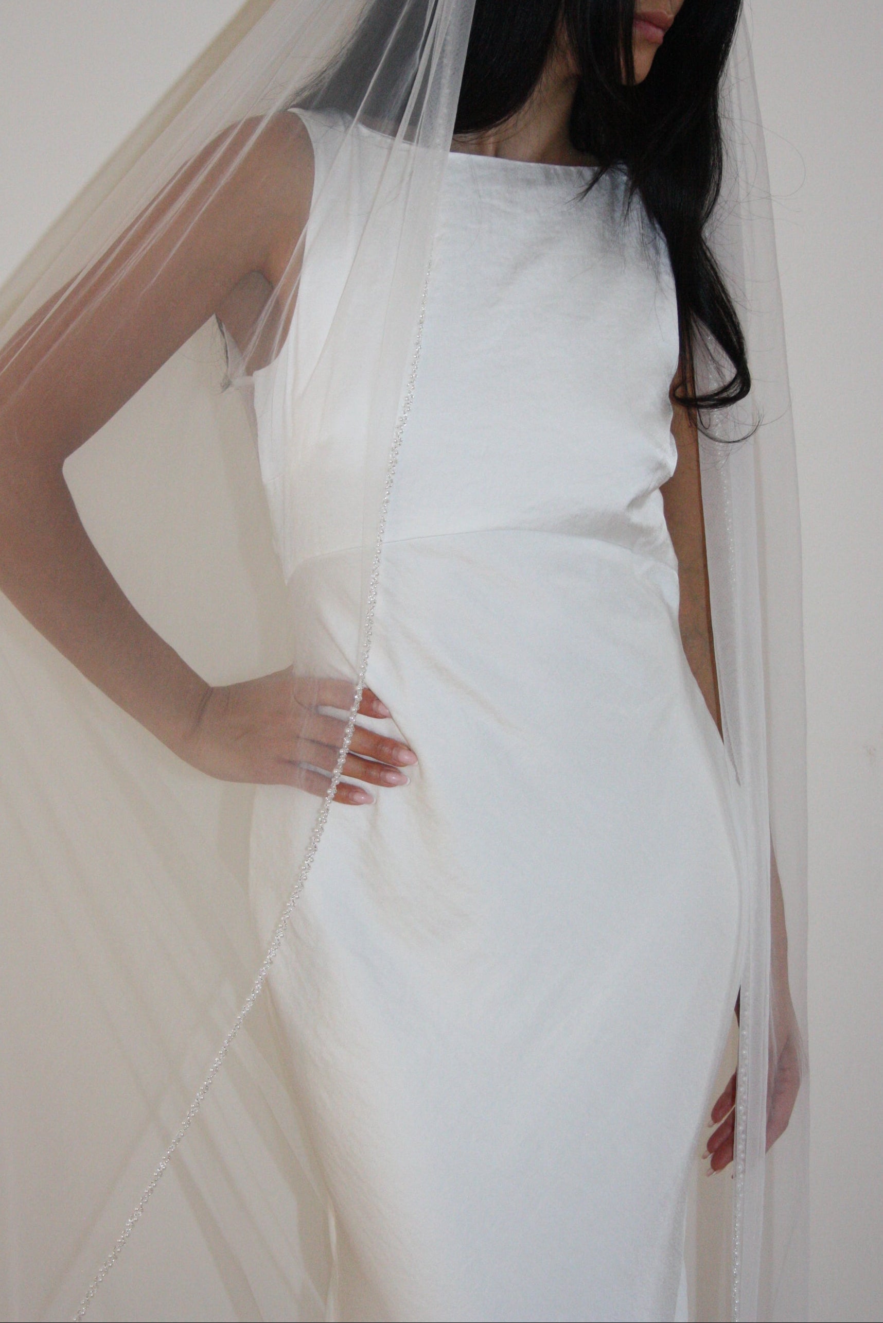 Soft tulle wedding veil with hand-placed pearl trim, perfect for modern and classic brides seeking an elegant bridal accessory