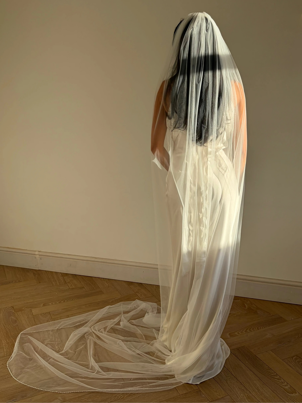 The Cathedral-Length Pearl Trim Veil features soft tulle and pearls & beads for a timeless, romantic bridal look. Lightweight and ethereal, it drapes beautifully for a graceful, luminous finish — perfect for modern or classic brides. The cloak-like full length veil finish is perfcet for the ethreal look.