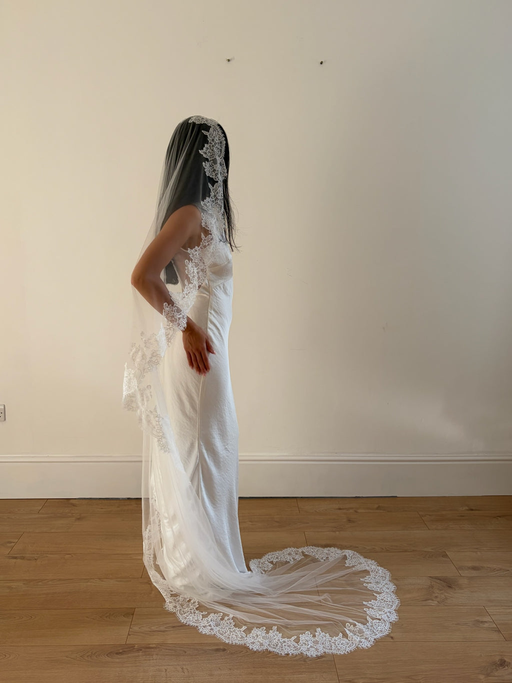 Soft off-white chapel bridal veil made from lightweight tulle with delicate lace trim along the edges for a dreamy, romantic look