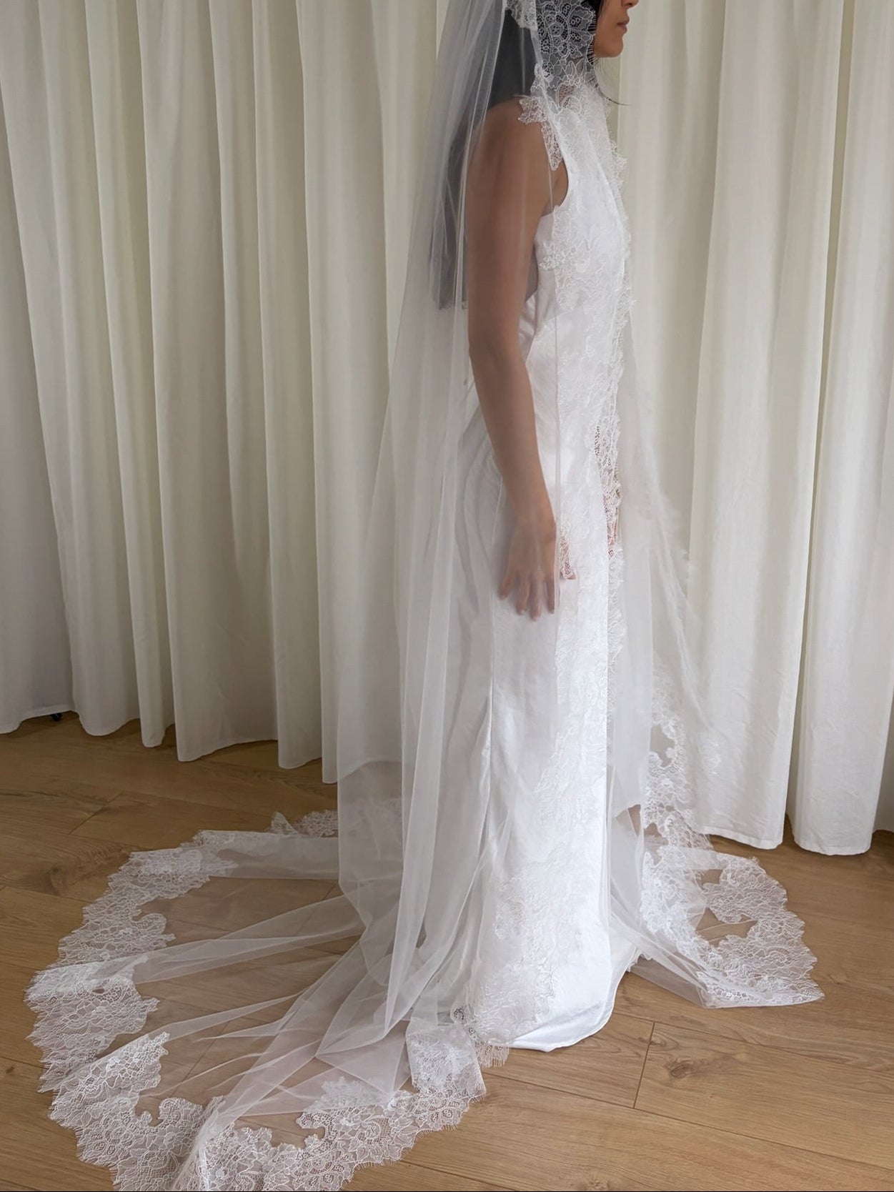 Cathedral-length wedding veil crafted from soft off-white tulle with an intricate Chantilly lace trim, ideal for brides wanting a romantic, elegant bridal accessory