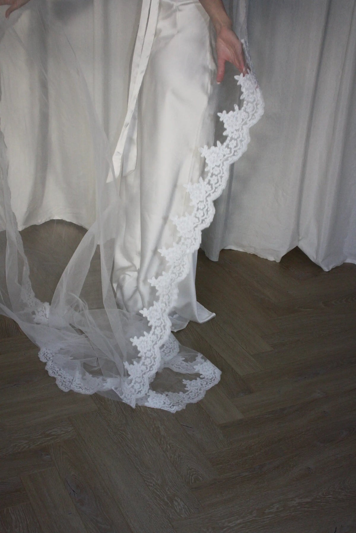 Lace trim bunched mantilla veil combines cathedral-length drama with hauntingly soft elegance. Made from luxurious, lightweight tulle and finished with fine lace edging, it falls straight to the ground in a flowing, cloak-like drape. Designed for brides seeking a romantic and timeless silhouette