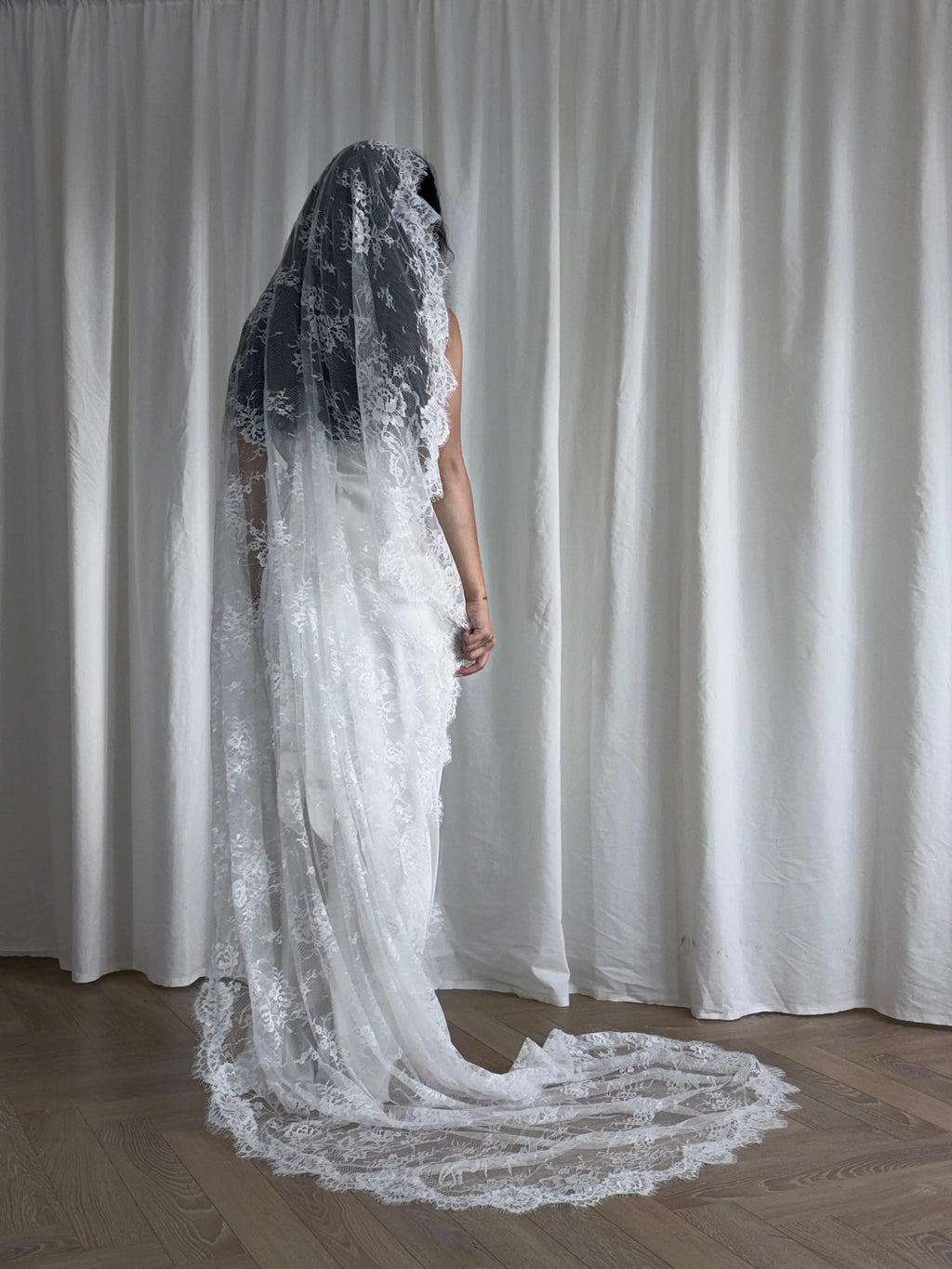 The Mantilla-Style Chantilly Rose Full Lace Veil is a cathedral-length bridal statement piece, designed for timeless elegance. Made from soft, lightweight tulle, it features intricate Chantilly rose lace that frames the veil completely, creating a delicate, romantic finish. The veil drapes beautifully straight to the ground, evoking a graceful, ethereal silhouette.This a vintage take on spanish style mantilla veil.