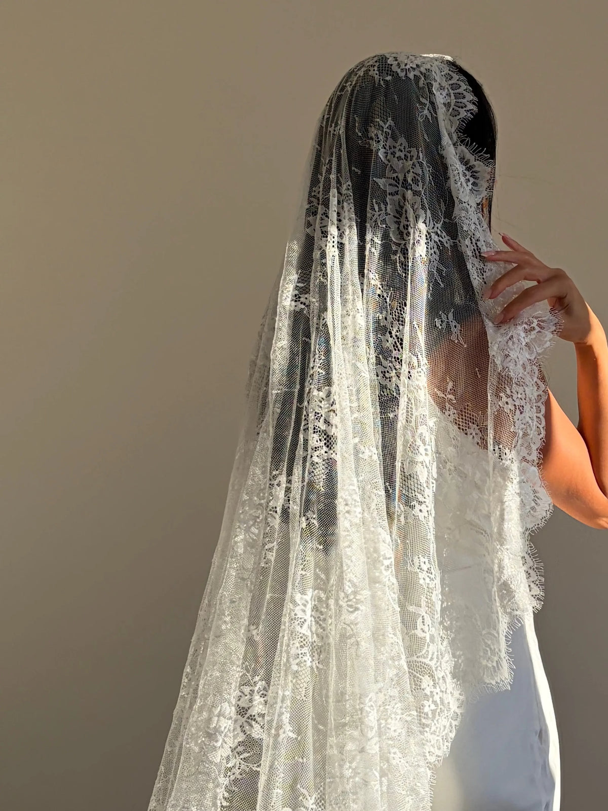 The Mantilla-Style Chantilly Rose Full Lace Veil is a cathedral-length bridal statement piece, designed for timeless elegance. Made from soft, lightweight tulle, it features intricate Chantilly rose lace that frames the veil completely, creating a delicate, romantic finish. The veil drapes beautifully straight to the ground, evoking a graceful, ethereal silhouette.This a vintage take on spanish style mantilla veil.