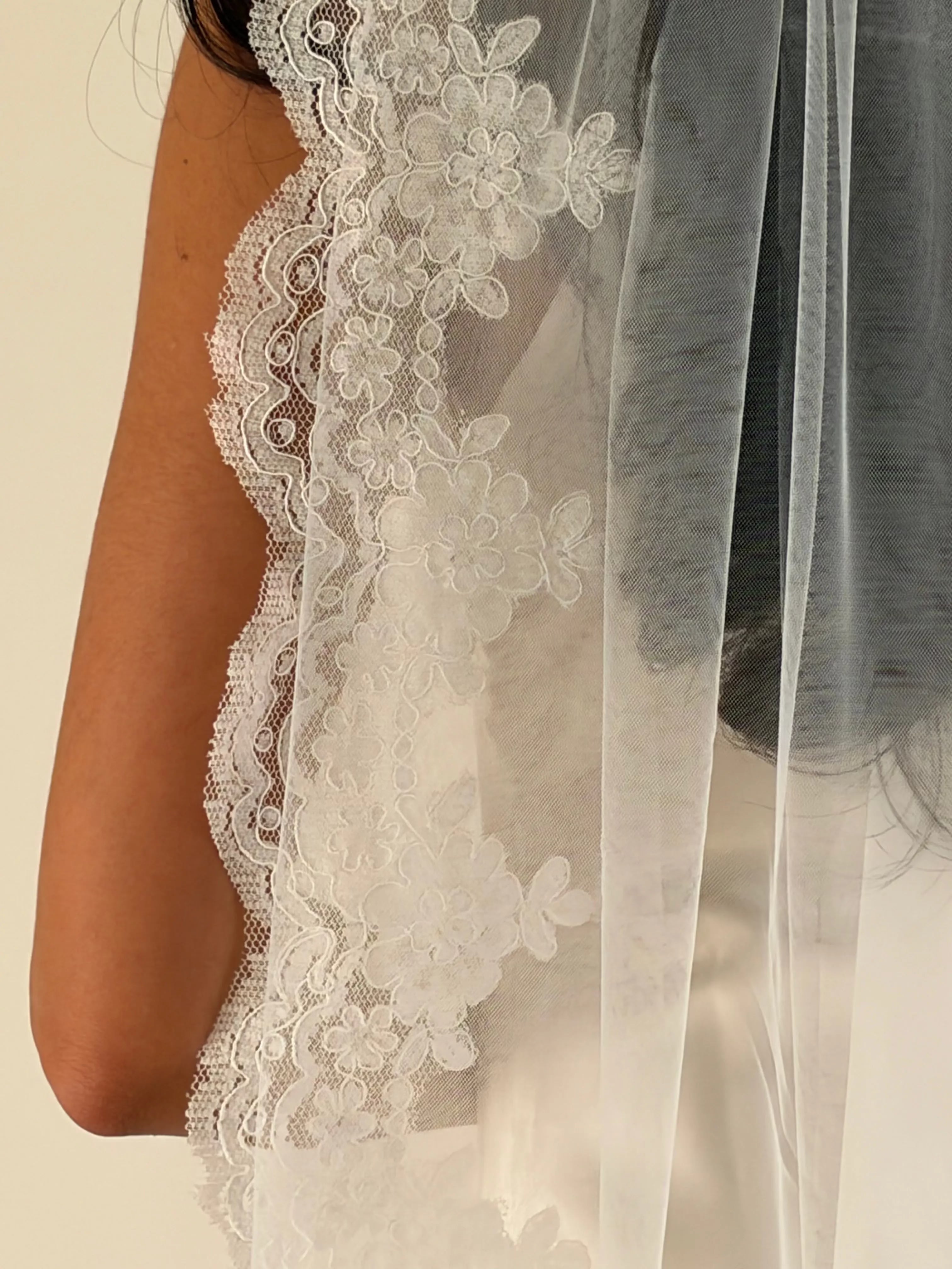 This pre-order lace trim bunched mantilla veil combines cathedral-length drama with hauntingly soft elegance. Made from luxurious, lightweight tulle and finished with fine lace edging, it falls straight to the ground in a flowing, cloak-like drape. Designed for brides seeking a romantic and timeless silhouette