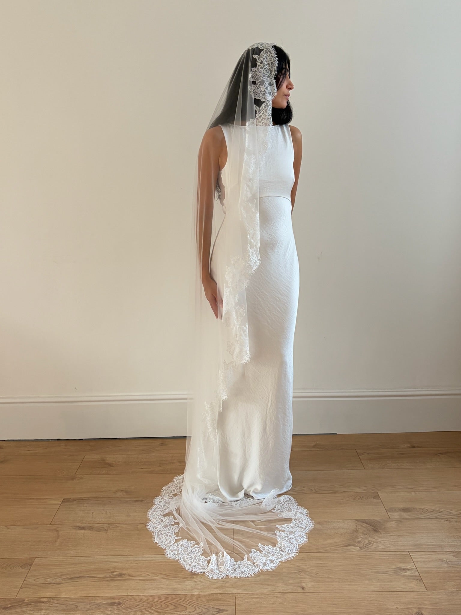 Soft off-white chapel bridal veil made from lightweight tulle with delicate lace trim along the edges for a dreamy, romantic look