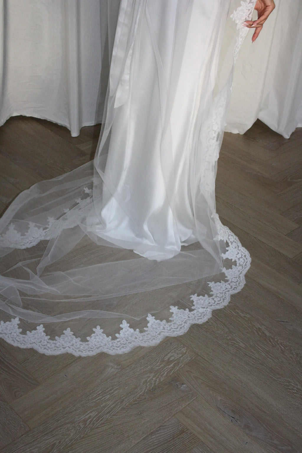 Lace trim bunched mantilla veil combines cathedral-length drama with hauntingly soft elegance. Made from luxurious, lightweight tulle and finished with fine lace edging, it falls straight to the ground in a flowing, cloak-like drape. Designed for brides seeking a romantic and timeless silhouette