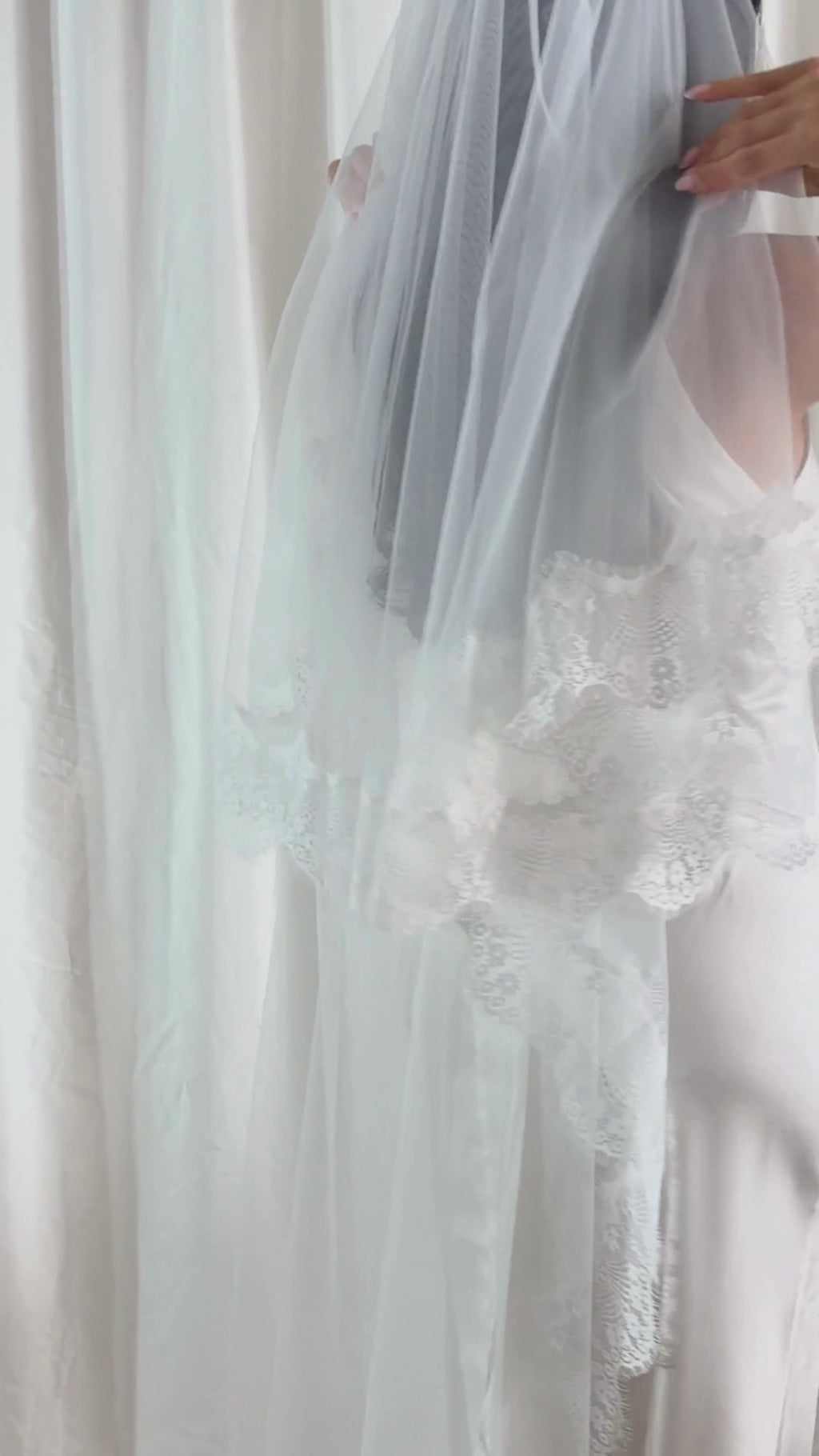 The Eyelash Lace Trim Blusher Veil combines classic romance with modern elegance. Designed in a two-tier silhouette, the blusher layer softly veils the face, while the cathedral-length tulle cascades gracefully to the floor, creating a breathtaking floating effect. Finished with intricate eyelash lace along the edge, this veil adds delicate texture and feminine detail. The lightweight construction ensures an effortless drape and comfortable wear throughout the day. Ideal for brides who want a timeless, ethe