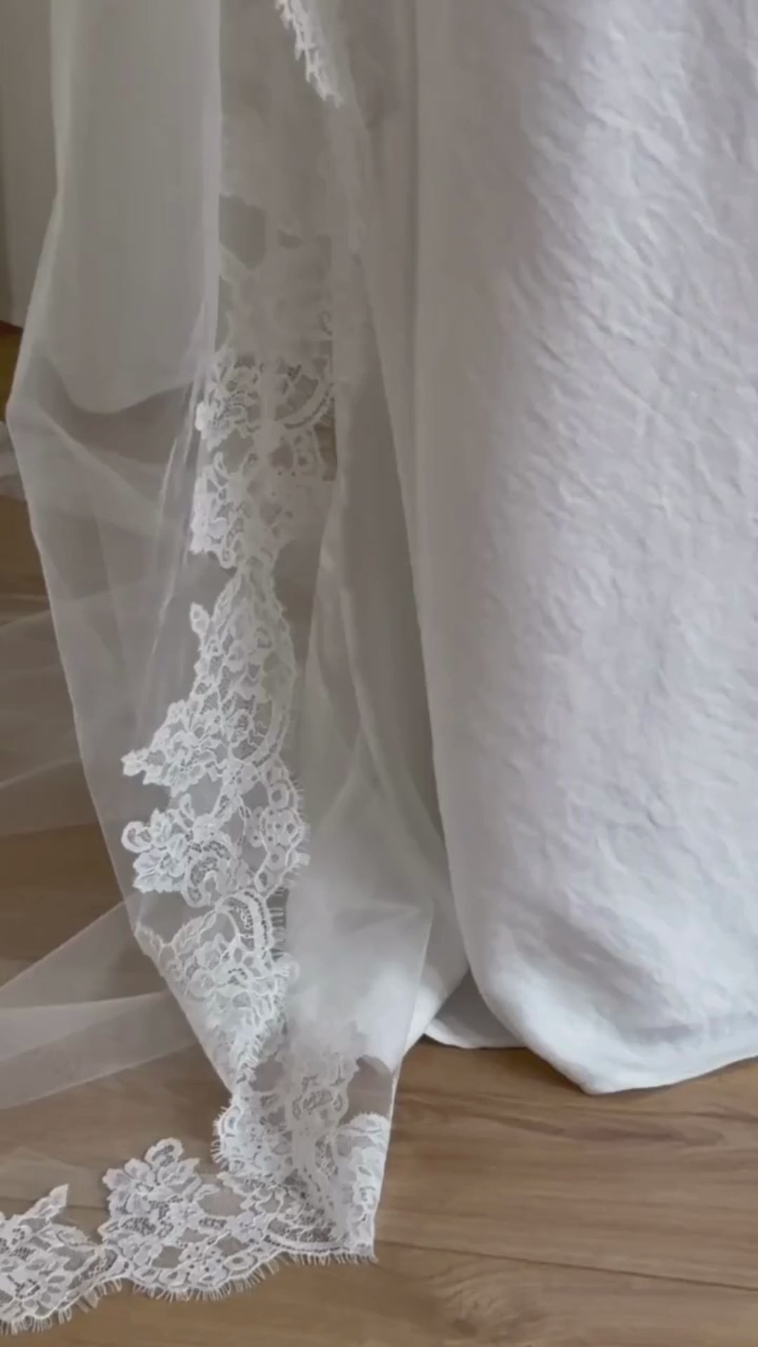 Soft off-white cathedral bridal veil made from lightweight tulle with delicate lace trim and a drop blusher, perfect for a dreamy, romantic look