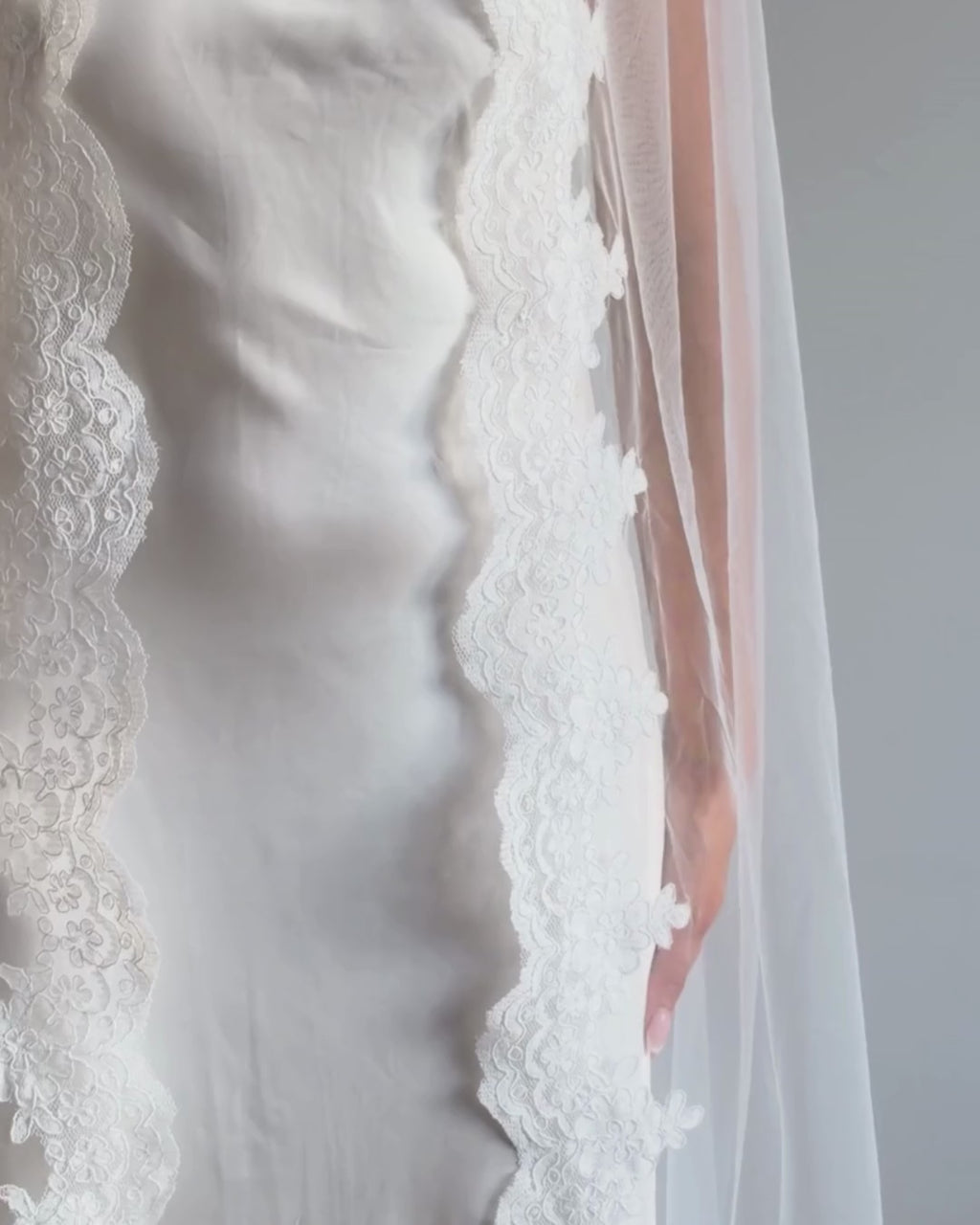 Draped vintage lace trim bunched mantilla veil combines cathedral-length drama with hauntingly soft elegance. Made from luxurious, lightweight tulle and finished with fine lace edging, it falls straight to the ground in a flowing, cloak-like drape. Designed for brides seeking a romantic and timeless silhouette.