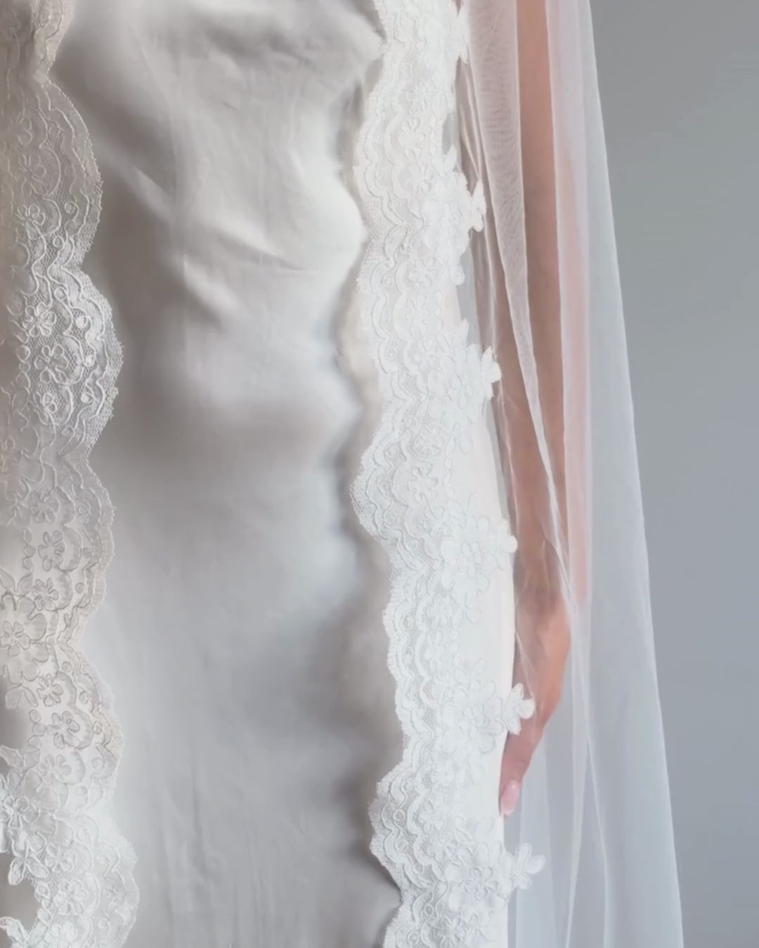Draped vintage lace trim bunched mantilla veil combines cathedral-length drama with hauntingly soft elegance. Made from luxurious, lightweight tulle and finished with fine lace edging, it falls straight to the ground in a flowing, cloak-like drape. Designed for brides seeking a romantic and timeless silhouette.