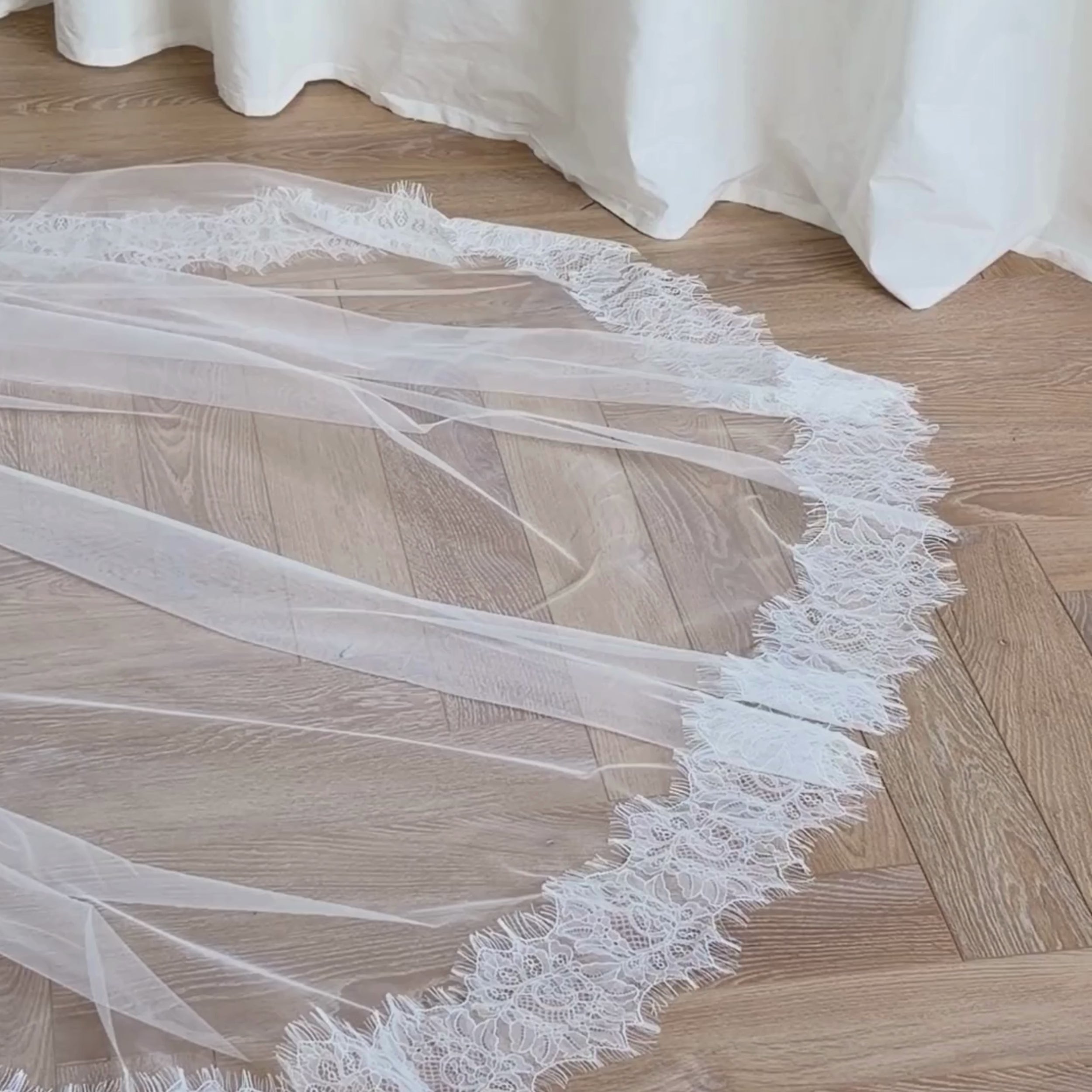 This vintage romantic blusher lace trim veil captures timeless bridal elegance. Made from luxuriously soft tulle, it features a delicate lace edge that frames the face and gown with effortless grace. The blusher layer adds a hint of vintage charm, creating a soft, ethereal silhouette ideal for traditional, chapel, or cathedral-length weddings. Perfect for brides seeking a romantic, classic look with refined detail and a seamless, airy drape.