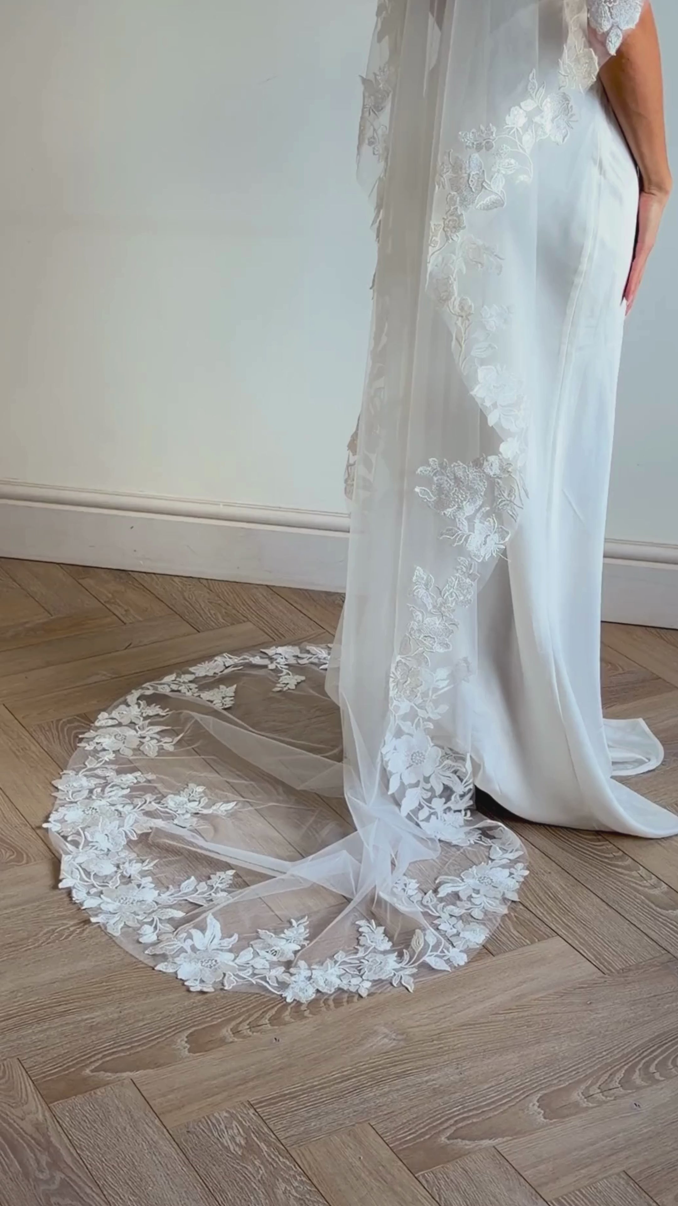The Embroidered Ethereal Garden Floral Lace Veil features fine sequin embroidery and hand-finished floral lace trim for a soft, ethereal glow. Crafted from luxurious tulle in a soft off-white tone, this romantic bridal veil drapes beautifully for a fairytale-inspired finish. Perfect for garden or cathedral weddings.