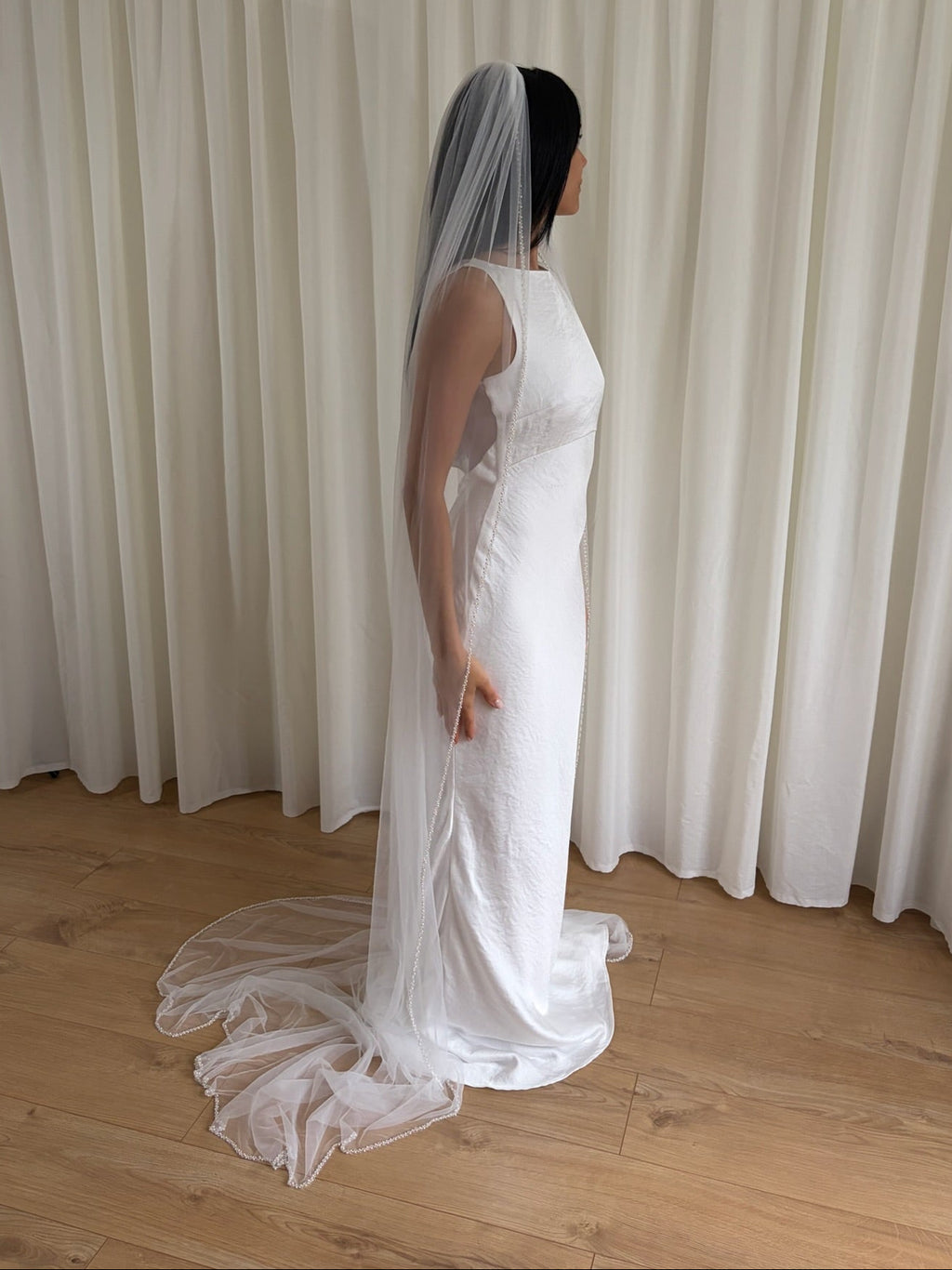 Soft tulle wedding veil with hand-placed pearl trim, perfect for modern and classic brides seeking an elegant bridal accessory