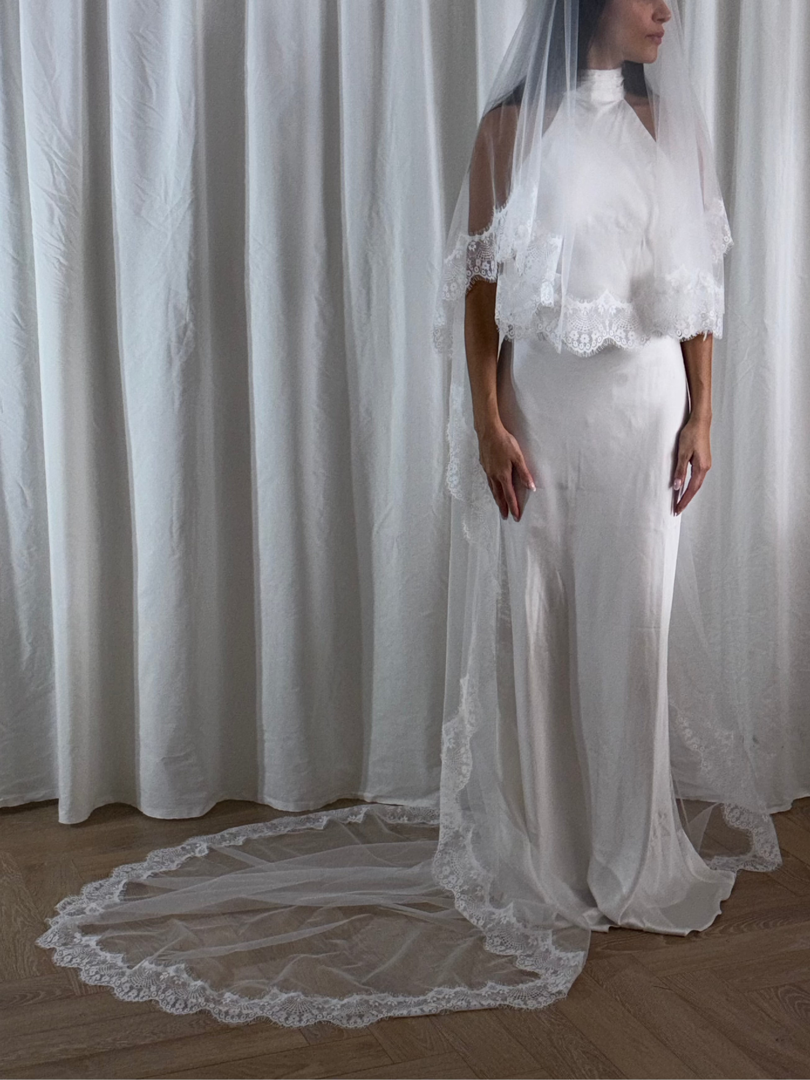 The Eyelash Trim Blusher Veil is a light, romantic accessory for modern brides seeking an ethereal finishing touch. Made from soft, flowing tulle, it features delicate eyelash lace along the edge for a subtle, feminine detail. The veil drapes softly over the face and shoulders, enhancing the bride’s silhouette with an airy, graceful effect. Its discreet comb attachment ensures a secure, seamless fit, making it ideal for both ceremony and photography. Perfect for adding a classic yet dreamy accent to any gow